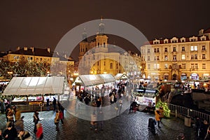 Christmas Market and lights of night in Prague, in 2016. Old Town Square with tourists. St. Nicholas Church