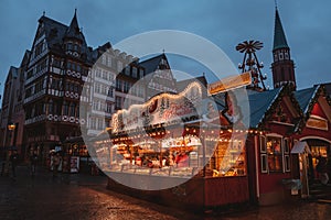 Christmas market spirit during snow night.