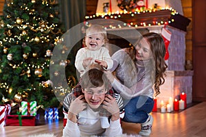 Christmas, x-mas, family, people, happiness concept - happy parents playing with pretty baby