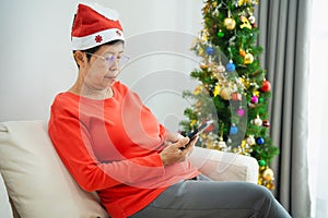 Christmas, x-mas, winter concept. Asian senior old woman using mobile phone to chat message smiling happy cheerful. Celebrates the
