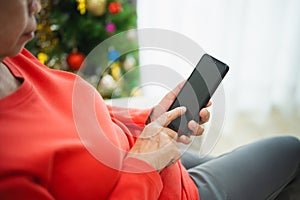 Christmas, x-mas, winter concept. Close up of hand, senior old woman using mobile phone to chat message happy cheerful. Celebrates