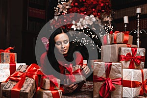 Christmas, x-mas, winter, happiness concept - smiling woman with many gift boxes with christmas tree