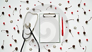 Christmas medical banner cones, red balls, snowflakes, stethoscope and tablet on white background top view. Copyspace. Medicine