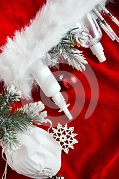 Christmas medical coronavirus flat lay, protective face mask, pills, antiseptics, decoration on red background