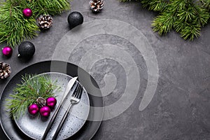 Christmas menu concept . Flat lay with Xmas decorations, dark plates, fork and knife set with napkin.