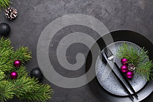 Christmas menu concept . Flat lay with Xmas decorations, dark plates, fork and knife set with napkin.