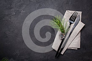 Christmas menu concept . Flat lay with Xmas decorations and pine cones, dark fork and knife set with napkin.