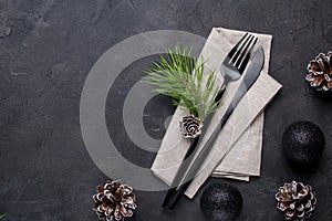 Christmas menu concept . Flat lay with Xmas decorations and pine cones, dark fork and knife set with napkin.