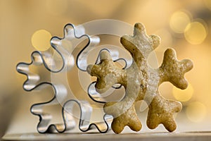 Christmas metallic and gingerbread snowflake cutter in magic Christmas lights on background