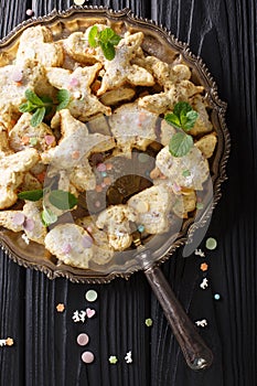 Christmas Mexican cookies hojarascas or biscochitos, pan de polvo and polvorones closeup on a plate. Vertical top view photo