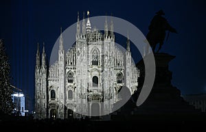 Christmas in Milan, Italy. The Duomo cathedral facade and a giant Christmas tree at night