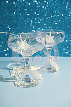 Christmas minimal festive background with star garland in glasses of champagne. Abstract Christmas and New Year color