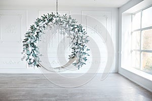 Christmas minimalism. White sitting ring with christmas decoration in modern white classical interior. Minimal christmas