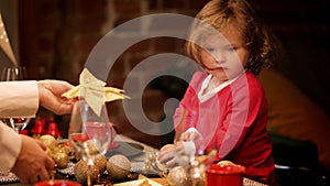 Christmas miracle little curly girl dreaming present with sitting beautiful decorated xmas table at home, kid preparing