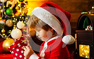 Christmas miracle and new year feelings. First memory of childhood. Boy winter clothes santa claus hat celebrate