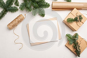 Christmas mockup greeting card with envelope on wooden white background with fir tree branches and happy new year