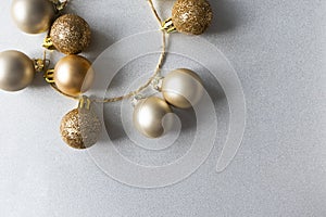 Christmas modern golden matte and glitter balls on shiny silver background with copy space, above. New Year decoration