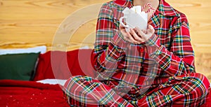 Christmas morning, girl in pajamas with a cup of hot cocoa with marshmallows. Selective focus photo