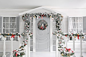 Christmas morning. porch a small house with a decorated door with a Christmas wreath. Winter fairy tale.