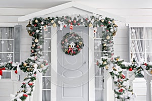 Christmas morning. porch a small house with a decorated door with a Christmas wreath. Winter fairy tale.