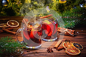 Christmas mulled red wine glÃ¼hwine with aromatic spices and citrus fruits on a wooden rustic table