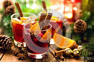 Christmas mulled red wine with spices and oranges on a wooden rustic table. Traditional hot drink at Christmas time