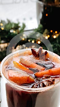 Christmas mulled wine on blurred background of bright lights. Traditional New Year's hot drink made from red wine