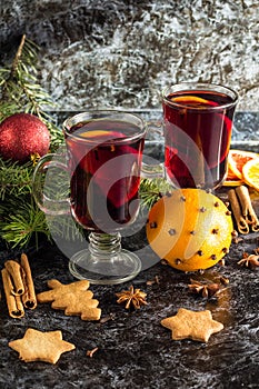 Christmas mulled wine with ginger biscuits orange cinnamon clove anise and fir tree on the dark table