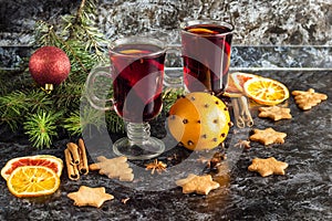 Christmas mulled wine with ginger biscuits orange cinnamon clove anise and fir tree on the dark table