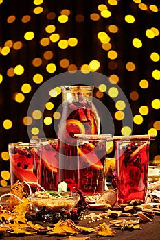 Christmas mulled wine or gluhwein with spices, chocolate sweets and orange slices on rustic table, traditional drink on winter photo