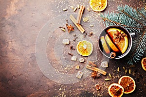 Christmas mulled wine or gluhwein with spices and orange slices on rustic table top view. Traditional drink on winter holiday.