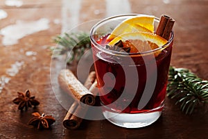 Christmas mulled wine or gluhwein with spices and orange slices on rustic table, traditional drink on winter holiday, magic light photo