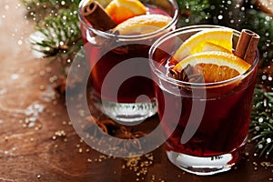 Christmas mulled wine or gluhwein with spices and orange slices on rustic table, traditional drink on winter holiday, magic light