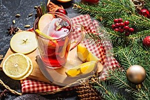 Christmas mulled wine with spices and orange slices on stone table. Traditional drink on winter