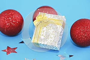 Christmas multicolored shiny red balls tree decorations and gift box with yellow bow for New Year holiday