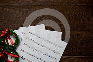 Christmas music note paper with Christmas wreath on wo