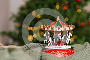 Christmas musical toy carousel on the background of the burning lights of the Christmas tree