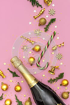 Christmas and New Year background. Champagne bottle, golden christmas balls, festive ribbons, fir branches, star confetti on pink