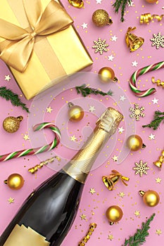 Christmas and New Year background. Champagne bottle, golden gift, christmas balls, festive ribbons, fir branches, star confetti on