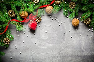 Christmas and New Year background. Christmas tree branch on a black background. Cones and fur-tree toys. View from above.