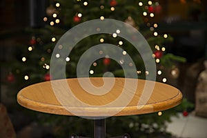 Christmas and New year background with empty wooden bar table over christmas tree and blurred light bokeh