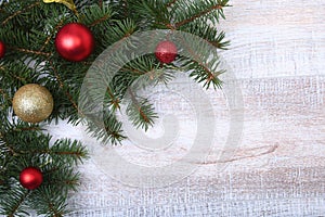 Christmas or New Year background: fur-tree, branches, colored glass balls , decoration and cones on a wooden background