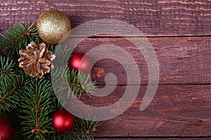 Christmas or New Year background: fur-tree, branches, colored glass balls , decoration and cones on a wooden background