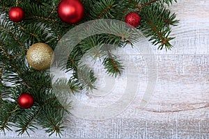 Christmas or New Year background: fur-tree, branches, colored glass balls , decoration and cones on a wooden background