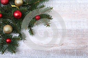 Christmas or New Year background: fur-tree, branches, colored glass balls , decoration and cones on a wooden background