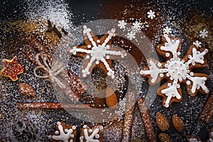 Christmas or New Year background of Gingerbread cookies, spices, nuts with sugar and snowflakes. Top view.