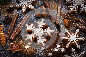 Christmas or New Year background of Gingerbread cookies, spices, nuts with sugar and snowflakes. Top view.