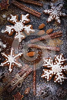 Christmas or New Year background of Gingerbread cookies, spices, nuts with sugar and snowflakes. Top view.