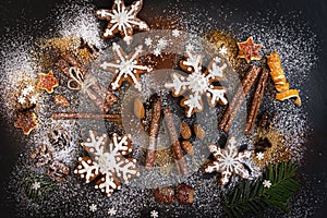 Christmas or New Year background of Gingerbread cookies, spices, nuts with sugar and snowflakes. Top view.