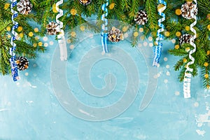 Christmas or New Year background with green fir branches and cones on blue background. Winter concept, top view, copy space